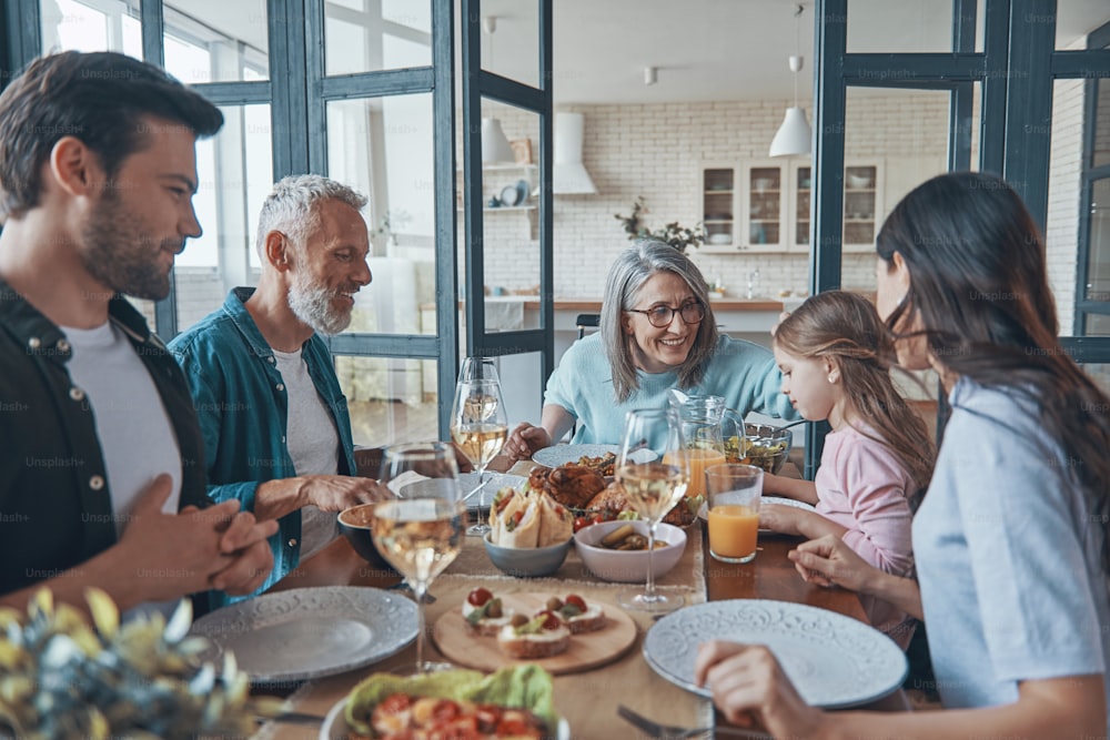 Happy multi-generation family smiling while having dinner together