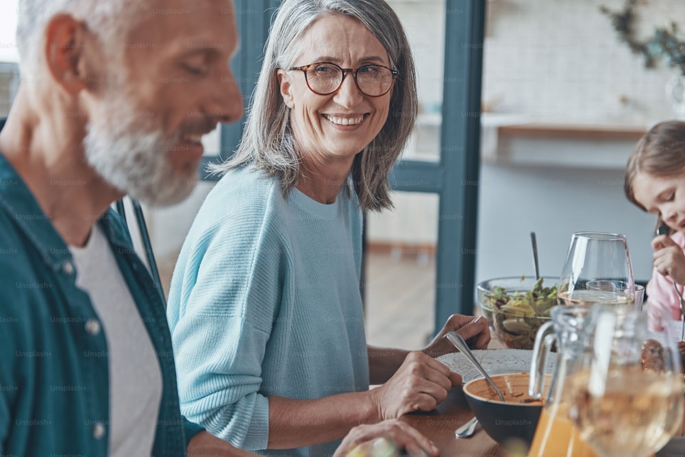 Happy senior couple communicating and smiling while having dinner together