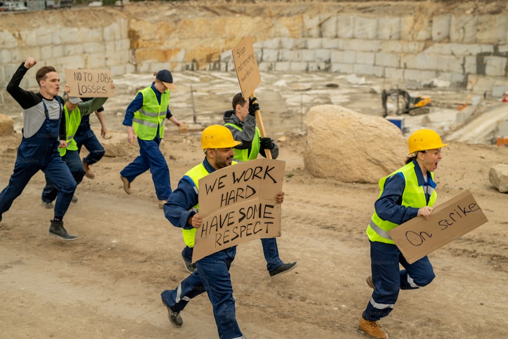 Foule de protestants avec des pancartes courant après leur employeur pendant la grève