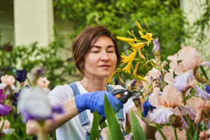 Female person looking after flowers and plants. Flower-garden and work outdoors