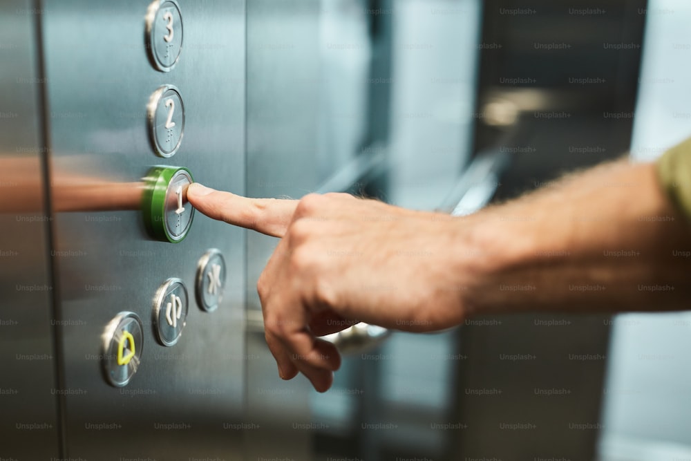 Close up of unrecognizable man pushing buttons in elevator, copy space