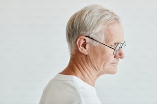 Retrato de vista lateral mínima do homem sênior de cabelos brancos no fundo branco, espaço de cópia