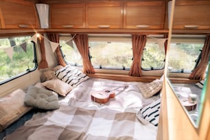 Group of wooden cabinets surrounding large bed with pillows inside house on wheels