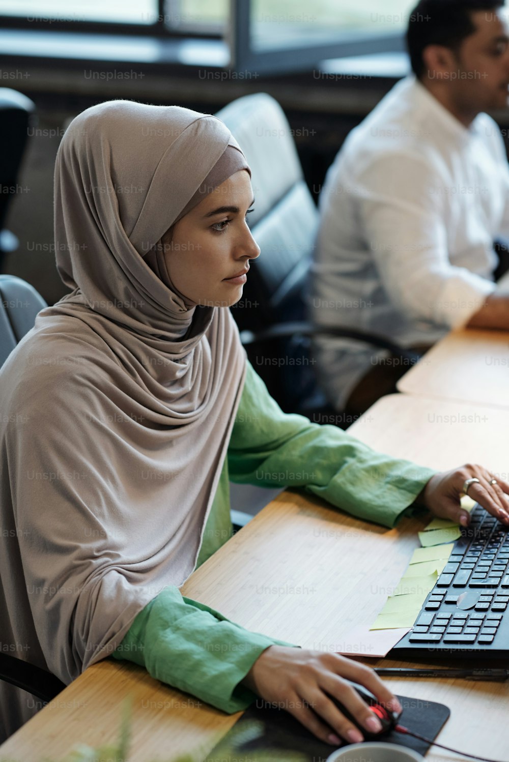 Pretty Muslim businesswoman in hijab sitting in front of computer during work