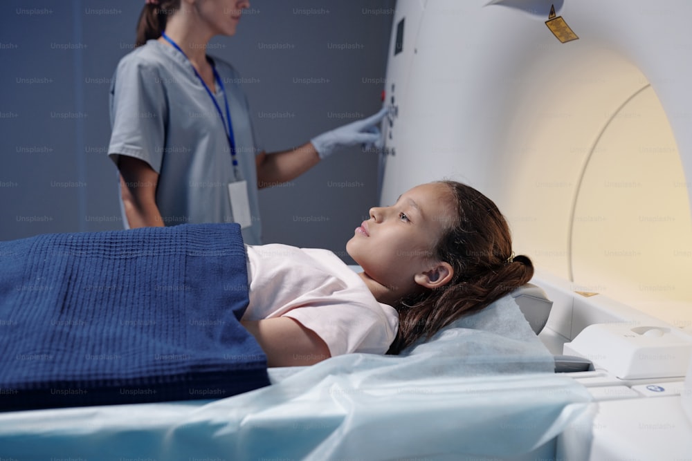 Bambina adorabile sottoposta a esame di tomografia computerizzata nella macchina di scansione