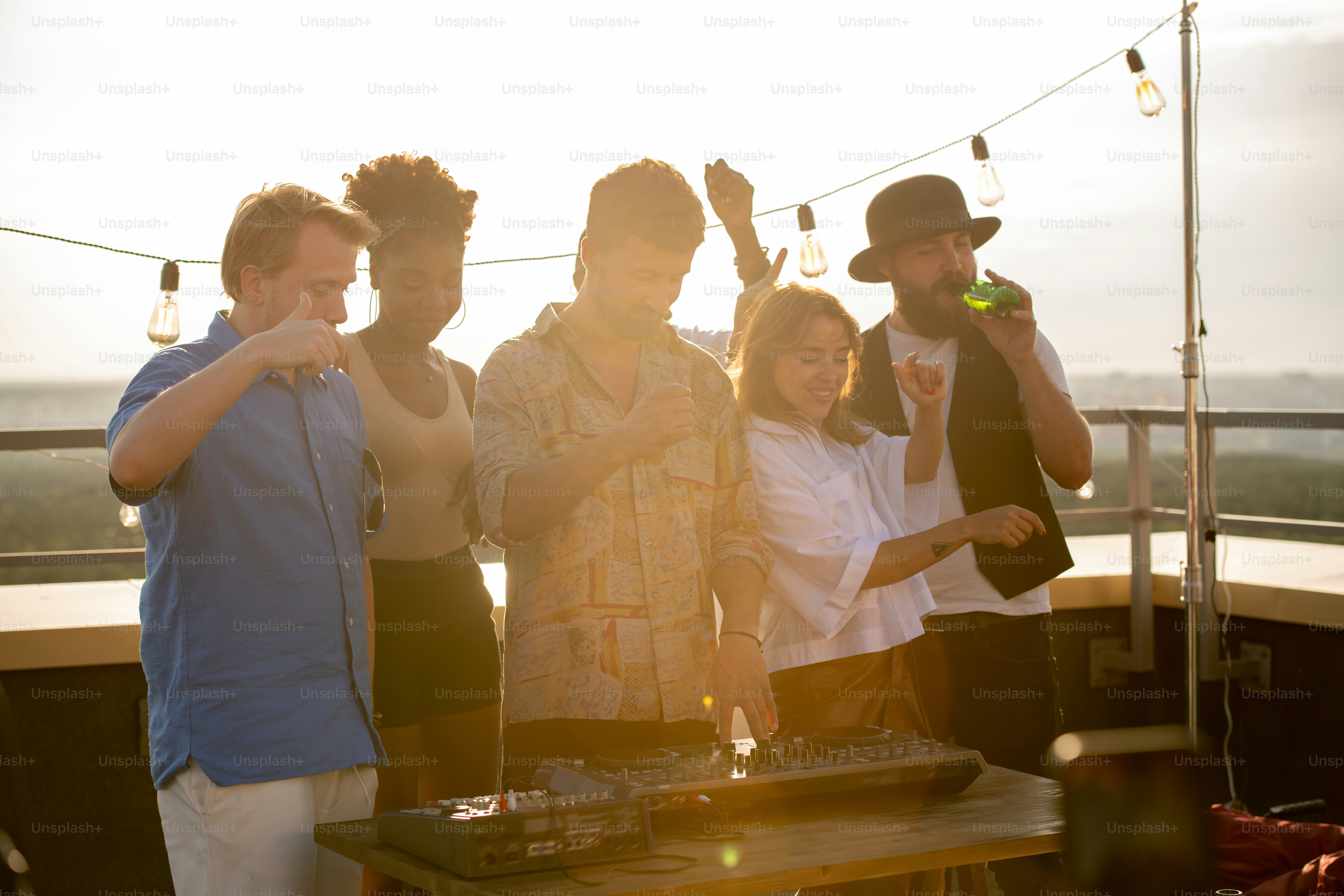 Happy young multiracial friends enjoying party at patio on rooftop