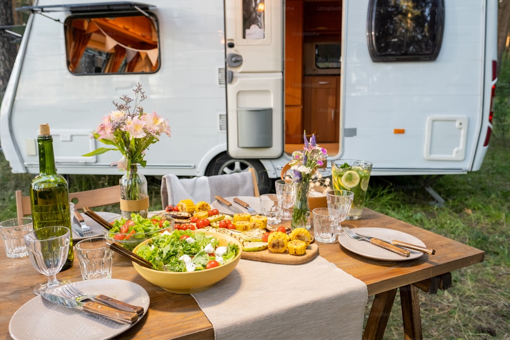 Table served with homemade vegetarian food against house on wheels with open door