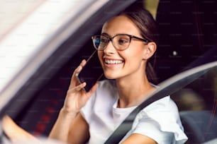 Una joven irresponsable conduce su coche y habla por teléfono. Es muy peligroso hacer eso cuando estás en la carretera.