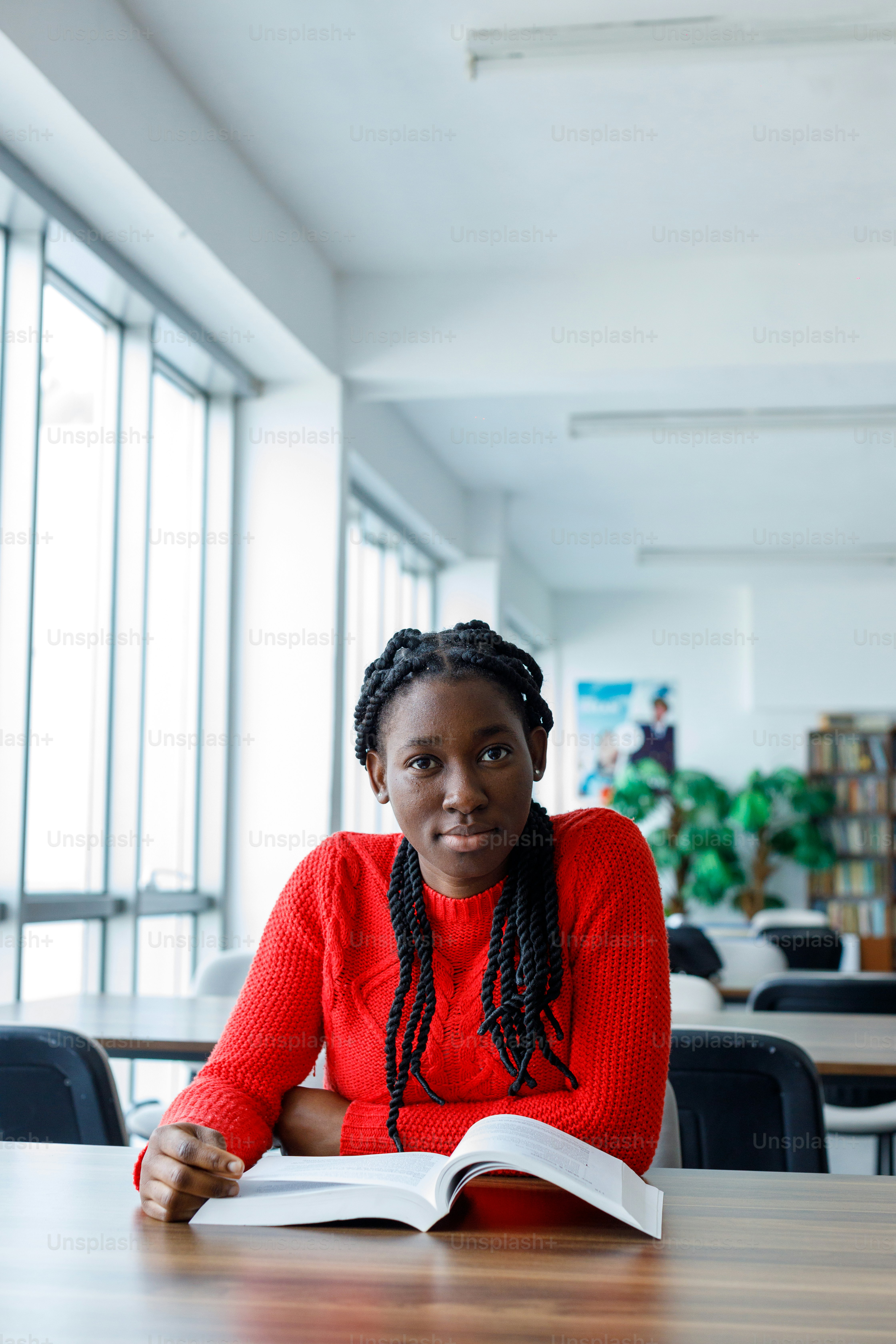 a woman sitting at a table with an open book