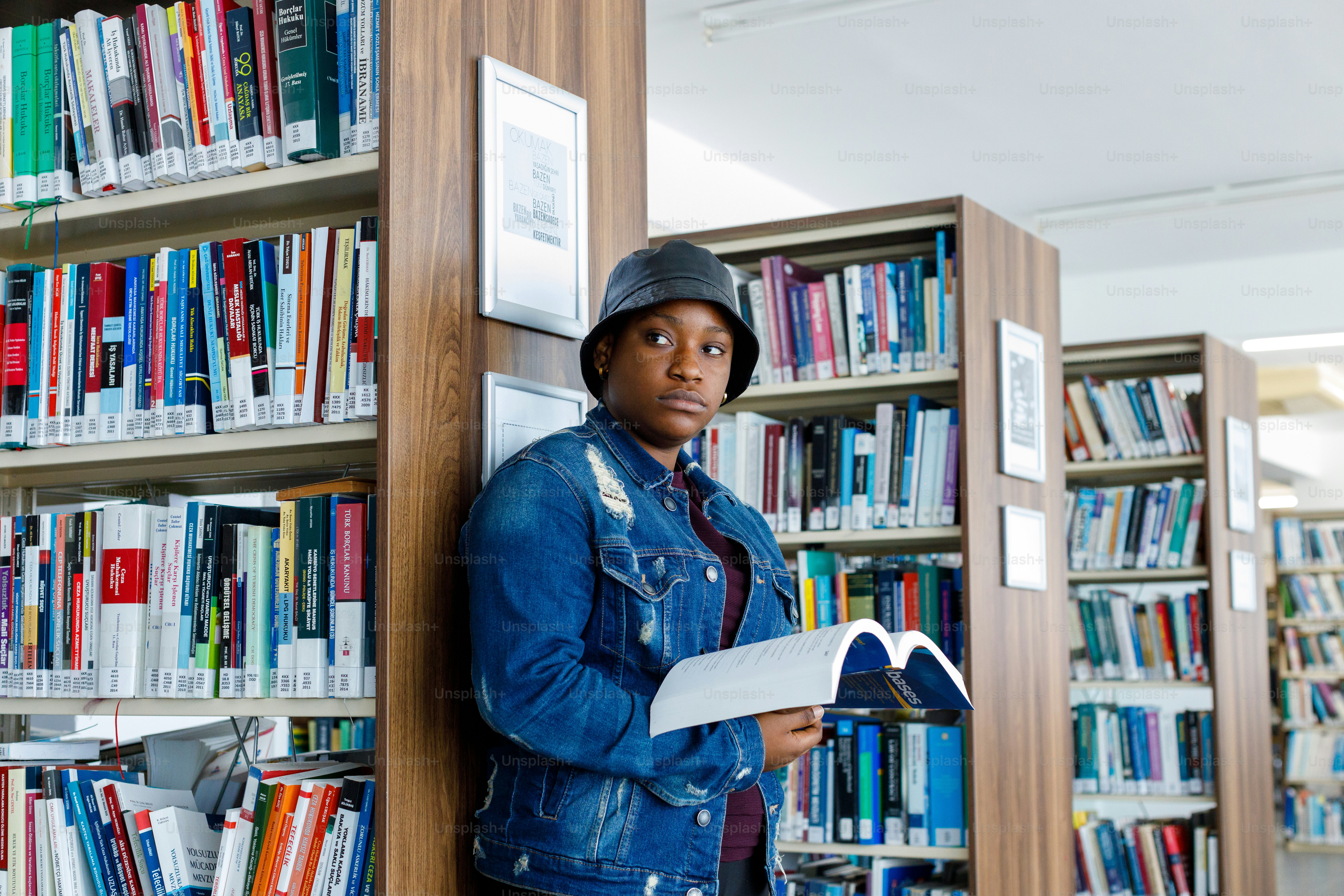 a woman leaning against a book shelf in a library