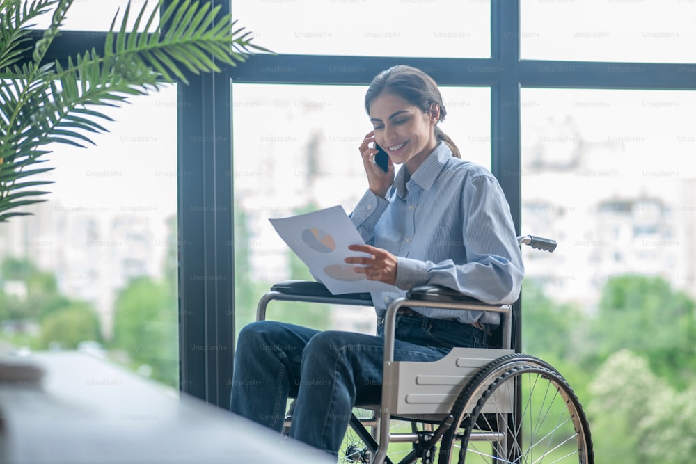 Working day. A disabled young woman talking on the phone
