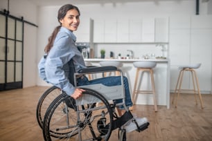 Deshabilitado. Una joven sonriente sentada en una silla de ruedas