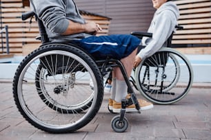 Close-up of people with disability sitting in wheelchairs and talking to each other they spending time outdoors