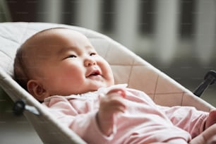 Close-up of chinese little child lying on the lounge chair and smiling