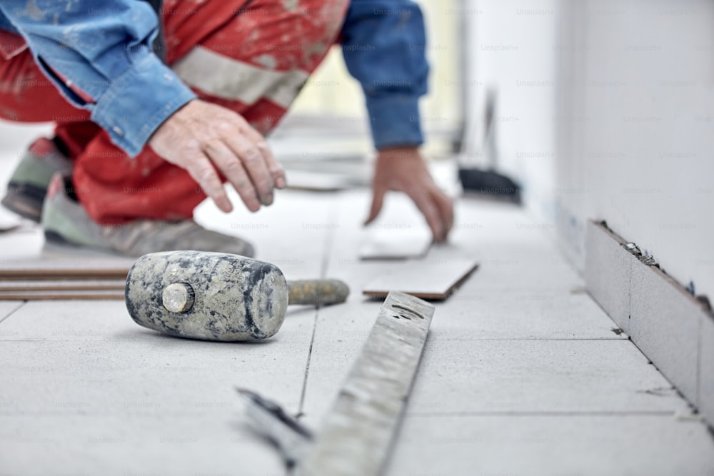 Professional ceramics tile man worker placing new tiles on the floor and wall.