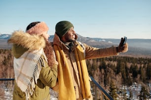 Multiracial dates making selfie on sunny day while enjoying travel in winter rresort