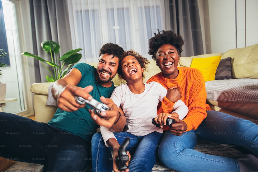 African American family playing video games together and having fun at home