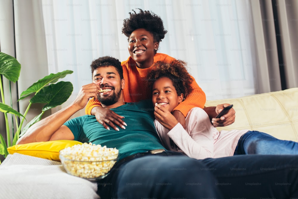 Relaxed african american family watching tv together.