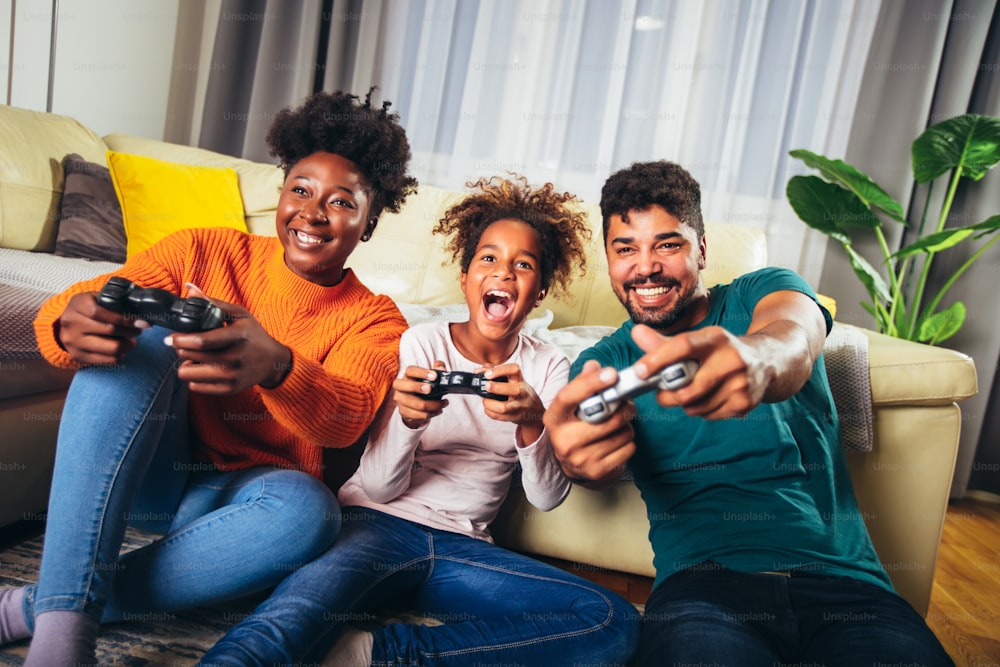 African American family playing video games together and having fun at home