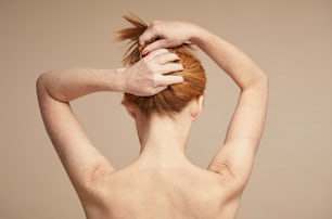 Minimale Rückansicht einer jungen rothaarigen Frau mit nackten Schultern, Kopierraum