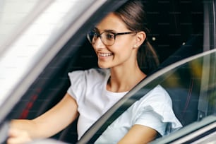 若い女の子が運転免許証を取得したばかりで、運転する準備ができています。若い女の子が車を運転する