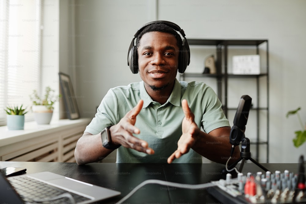 Retrato de homem afro-americano falando para a câmera enquanto grava podcast em estúdio