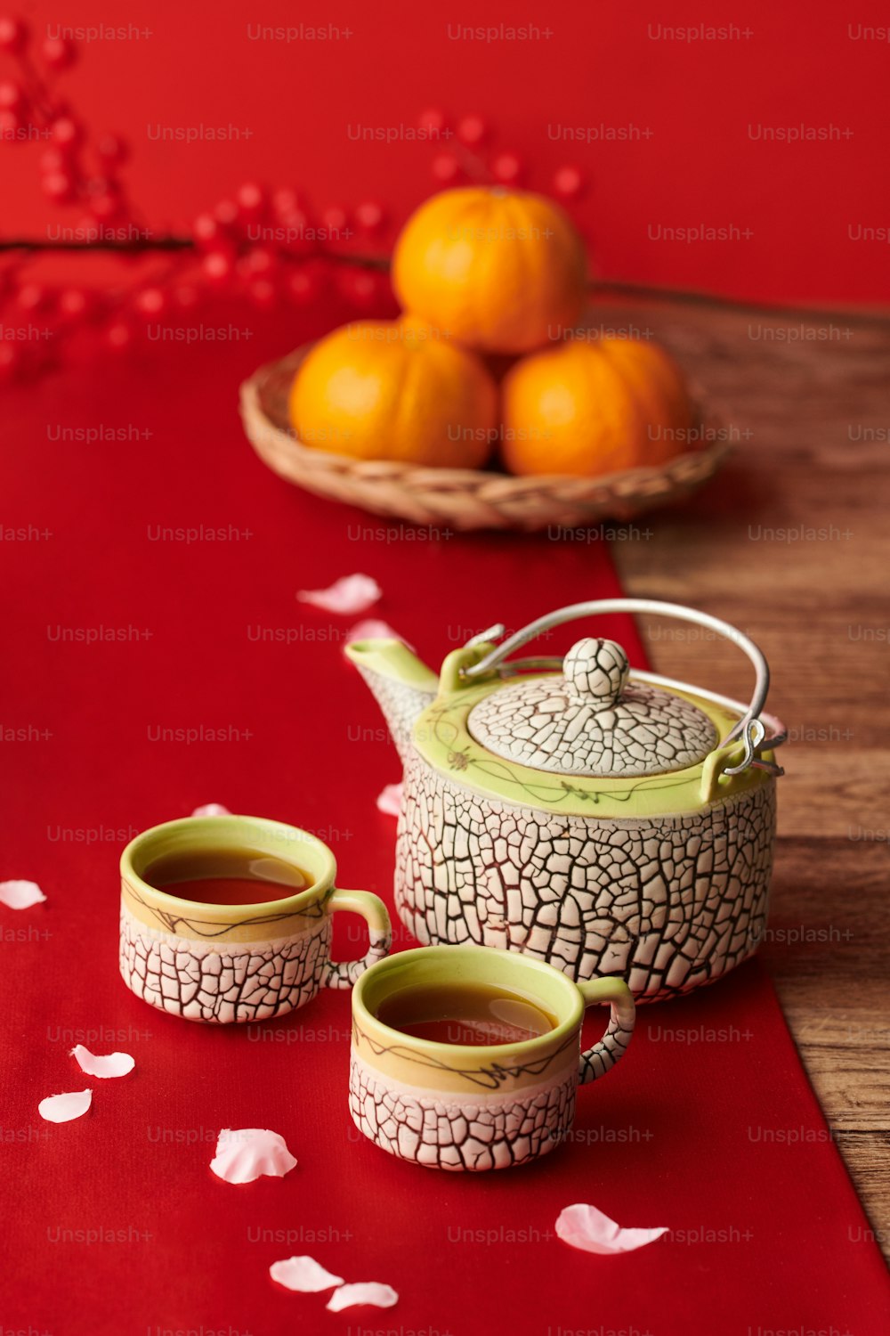 旧正月のお祝いに伝統的な赤い布で覆われたテーブルの上のポットと2杯のお茶