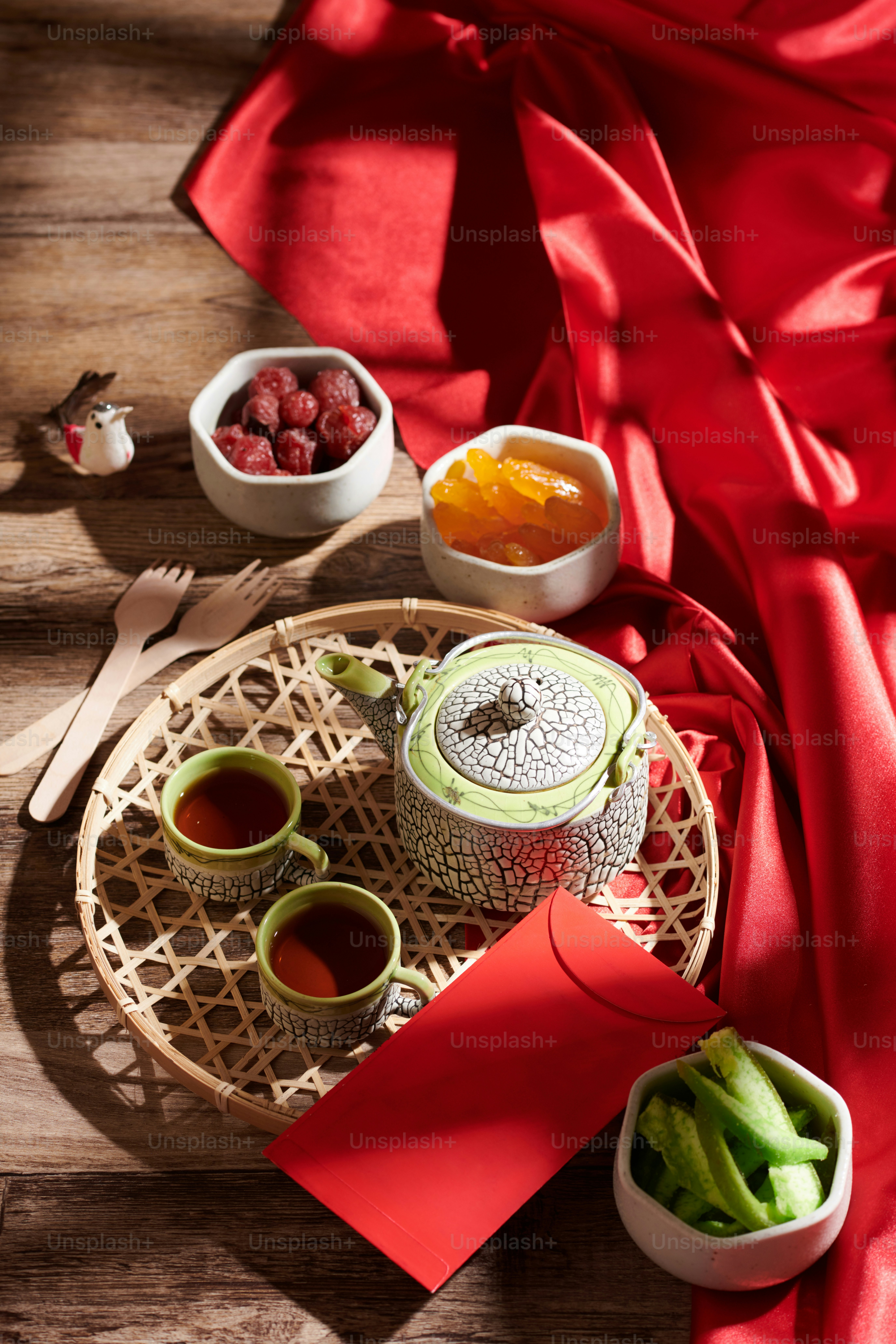 Tray with candied fruits and berries, tea pot and red envelope prepared for Lunar New Year