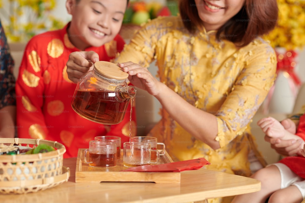 Mãe derramando chá para seu filho na celebração do Ano Novo Chinês