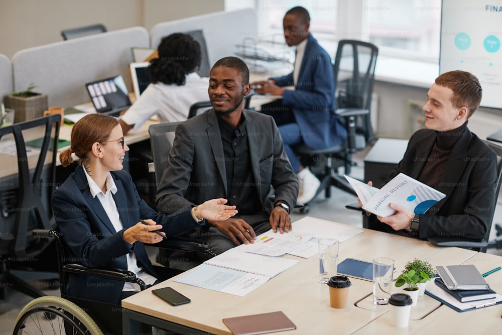 Side view portrait of young African-American businessman using wheelchair while working in office, copy space