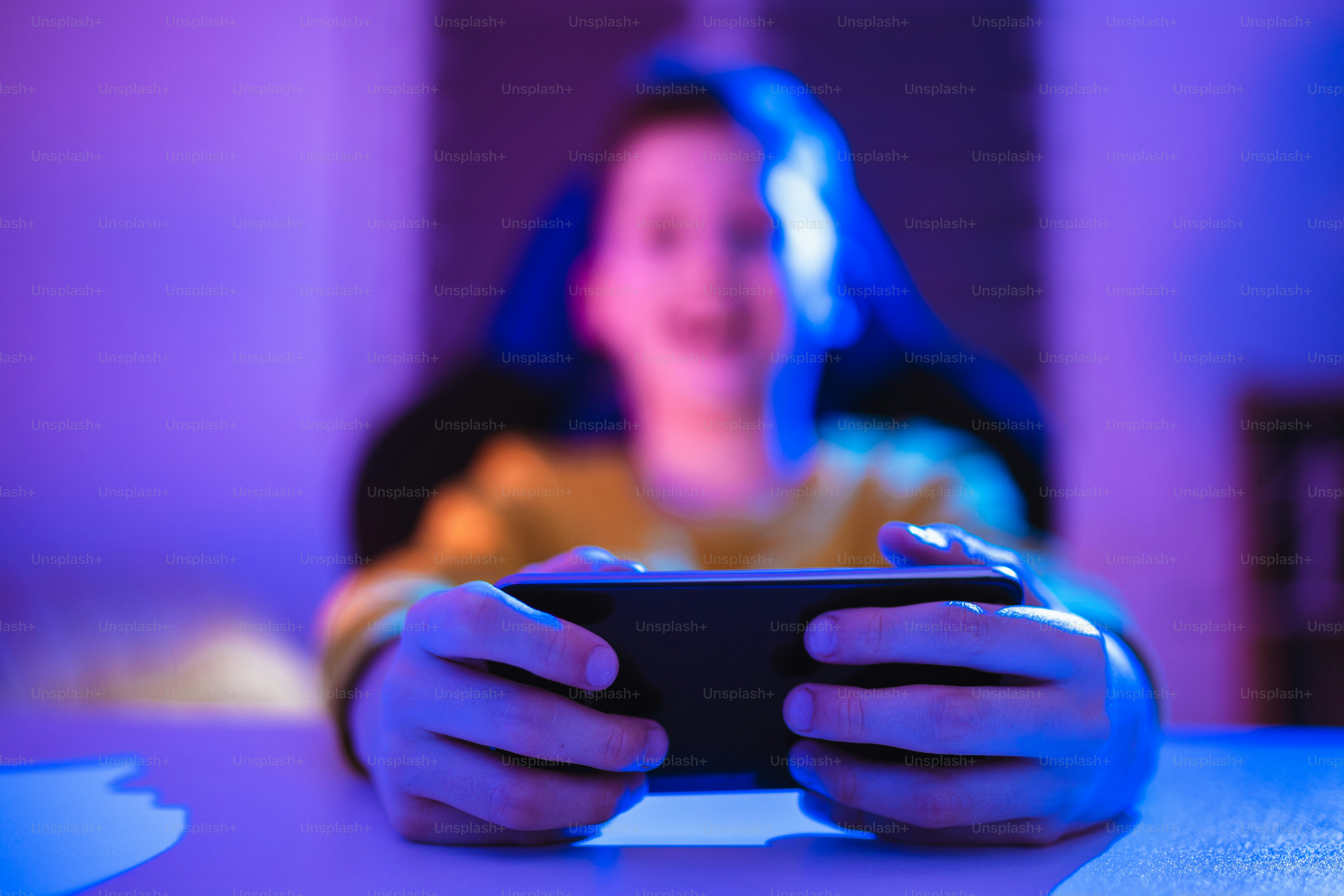 Boy playing videogame on smartphone in the evening at home