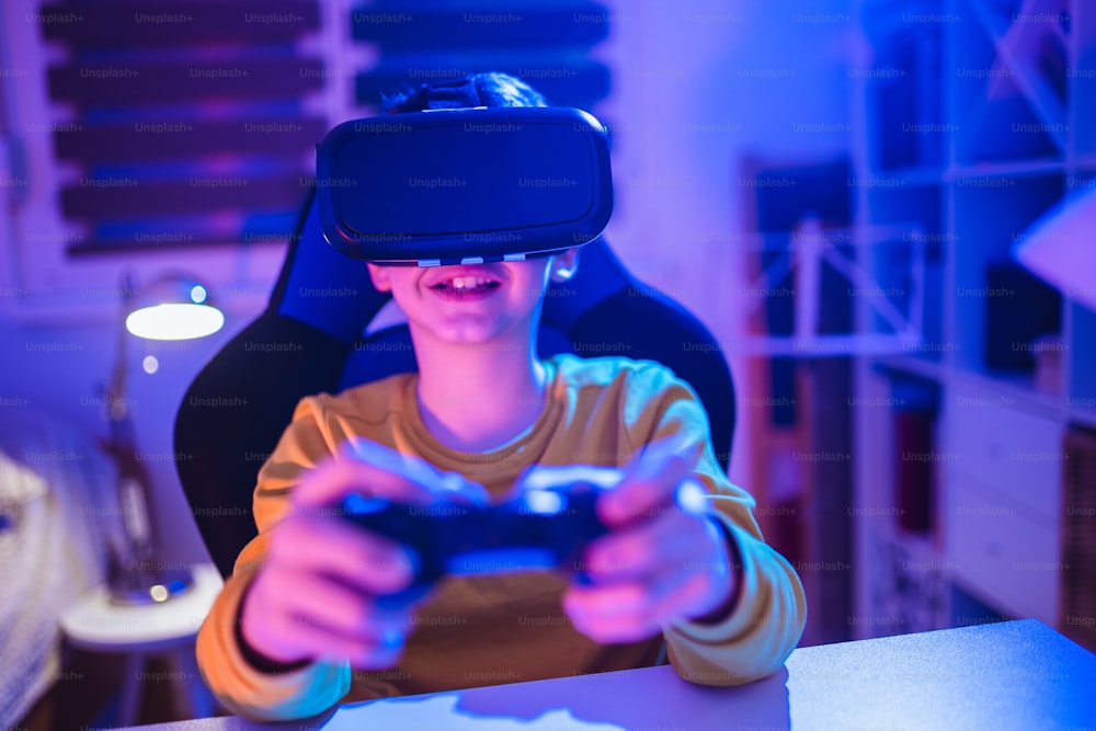 Little boy playing video game using vr glasses in the dark room