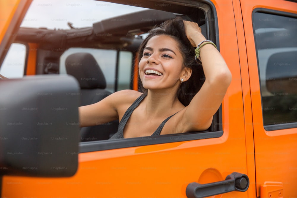 Glückliche fröhliche Frau, die ein Auto fährt