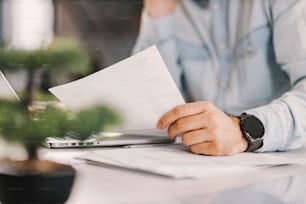 Close up of freelancer's hands holding paperwork at home.