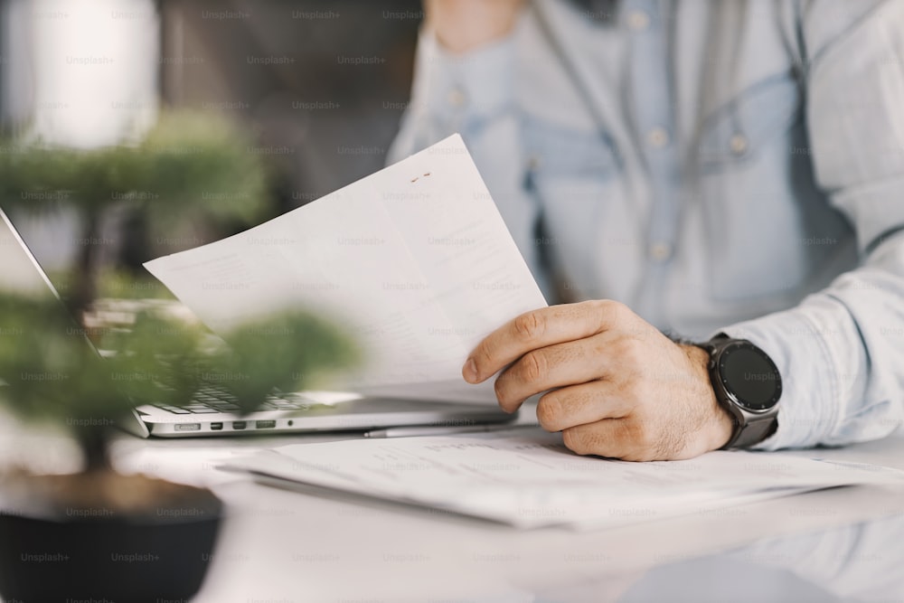 Primer plano de las manos del freelancer sosteniendo el papeleo en casa.