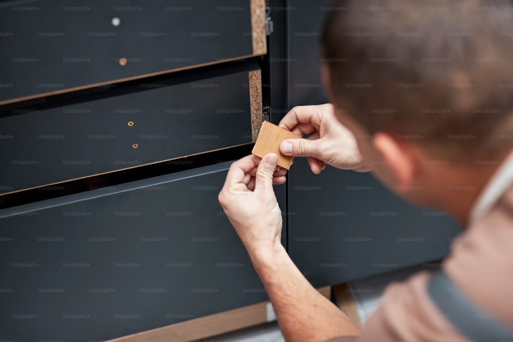 Handyman making kitchen wall cabinets in the apartment.