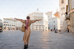 여자는 피렌체의 유명한 두오모 대성당에서 아름다운 전망을 즐기며 아침 시간에 빈 대성당 광장에 서 있습니다. 이탈리아의 랜드마크를 방문하는 세련된 여성. 이탈리아 여행 개념