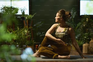 modern 40 years old woman with yoga mat stretching in the modern green house.