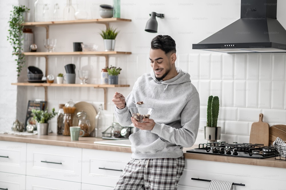 In the kitchen. A young man spending morning at home and having coffee