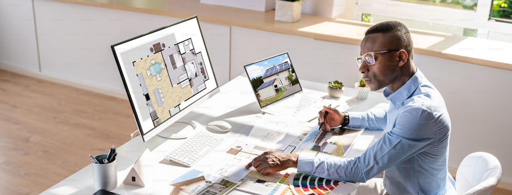 Side View Of Real Estate Designer Working On Computer In Office