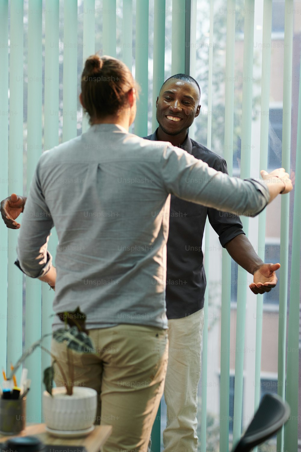 Excited businessman greeting and hugging colleague who returen to work after long absence