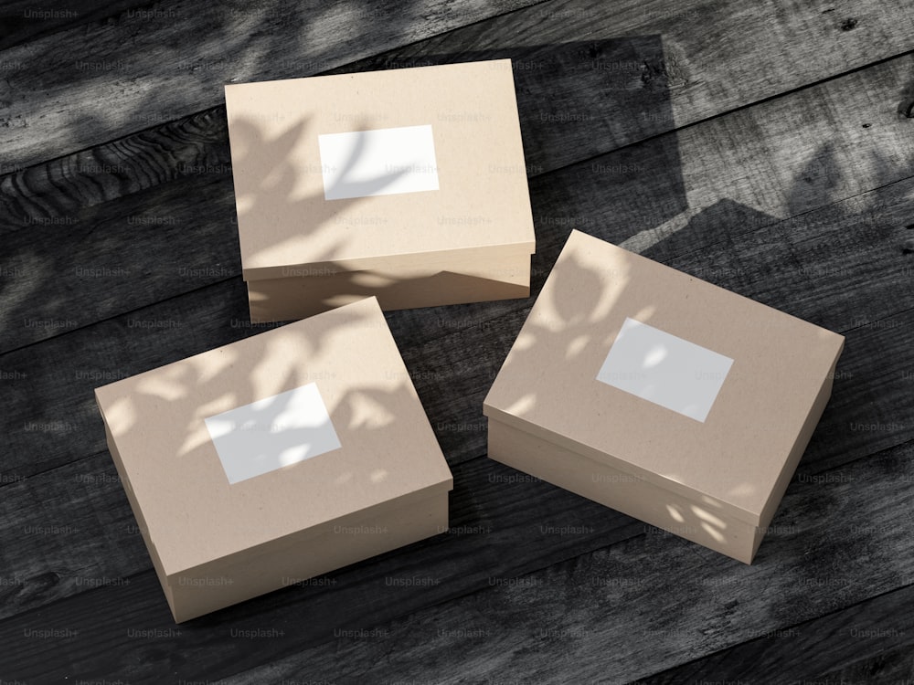 Tre scatole di cartone Mockup con carta adesiva bianca su tavolo di legno nero. Rendering 3D