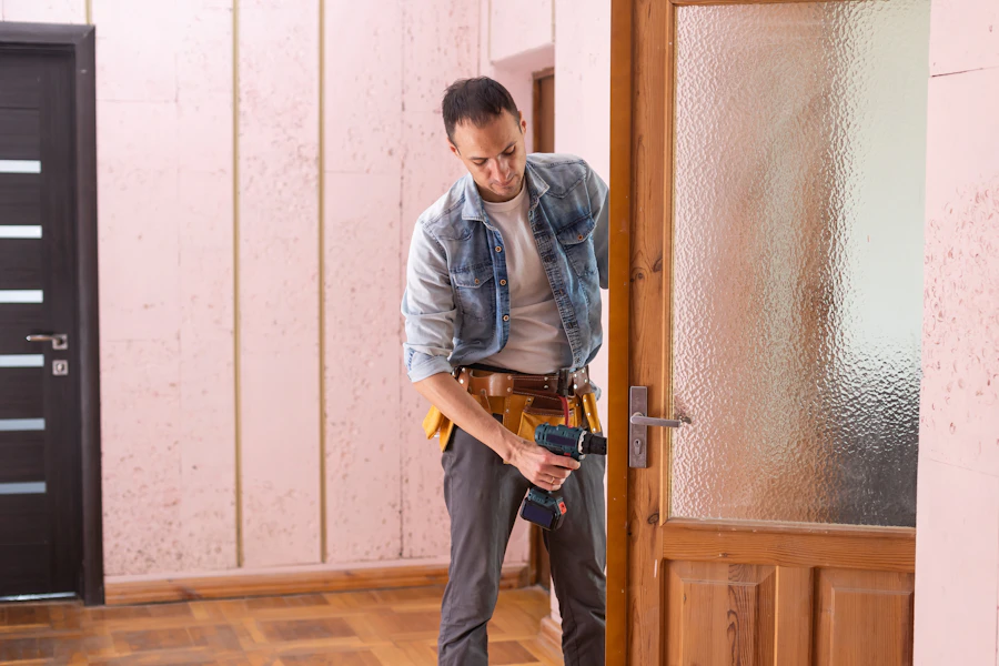 Handyman mounting shelving and fixtures to a wall