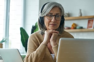 Senior woman looking at laptop while working from home