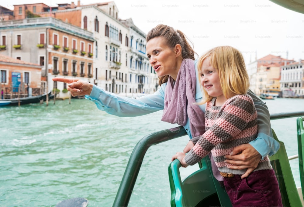 Baby girl and mother poiting while travel by vaporetto in venice, italy