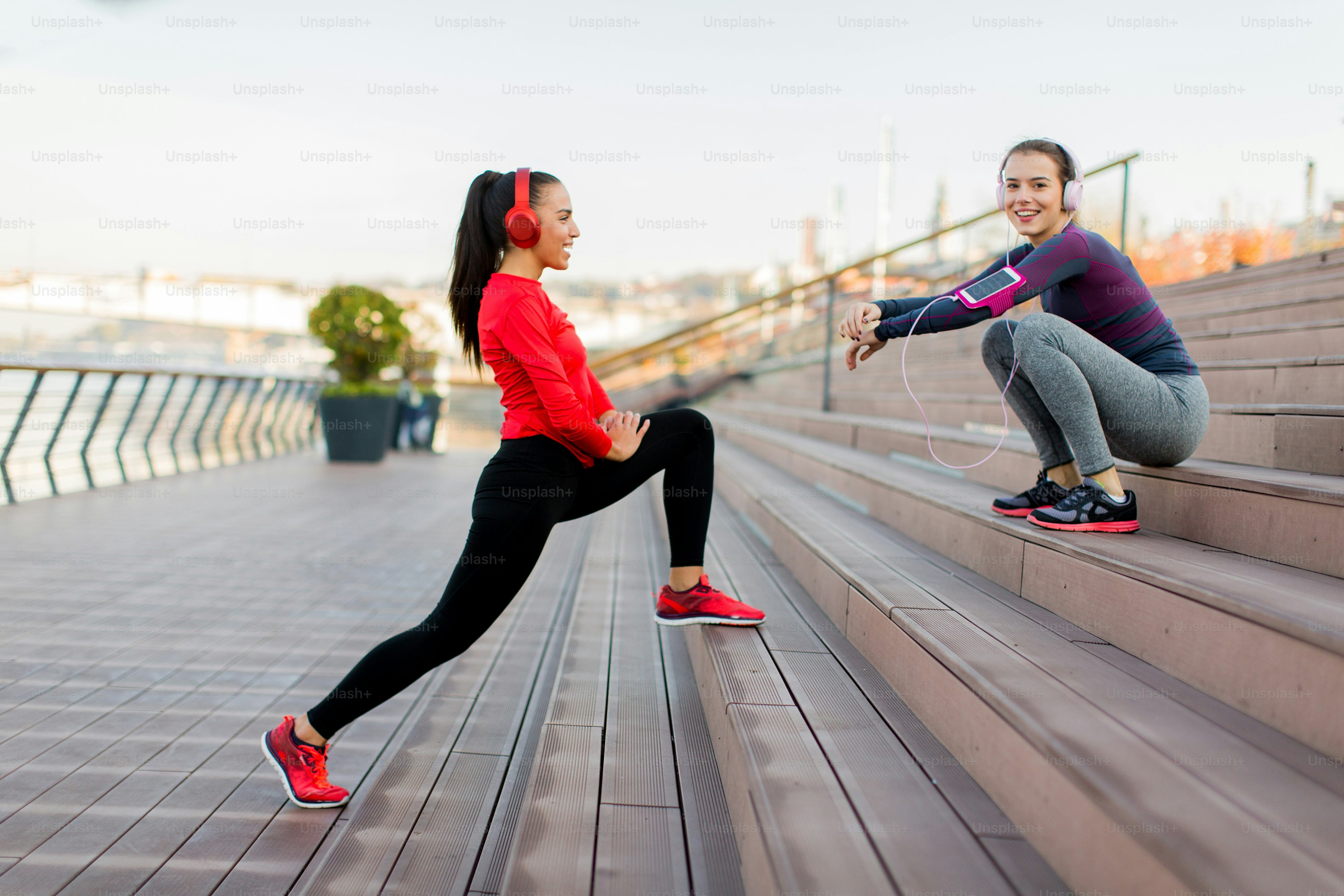 Young woman exercising with a personal trainer outside in the morning