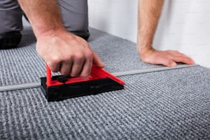 床にカーペットを敷く職人の手の接写