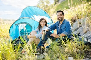 Portrait of a good looking Latin couple going on a hiking trip and camping on a mountain