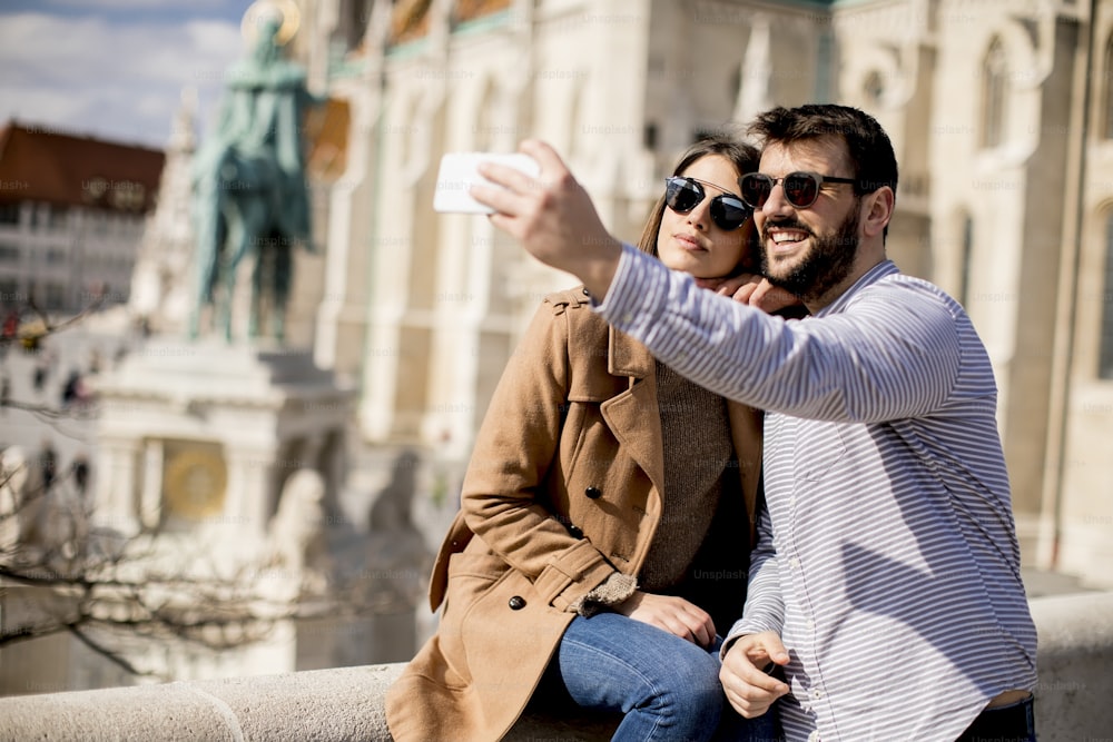Portrait of loving couple taking selfie in urban enviroment at sunny day