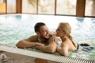 Loving couple relaxing in the pool at spa center